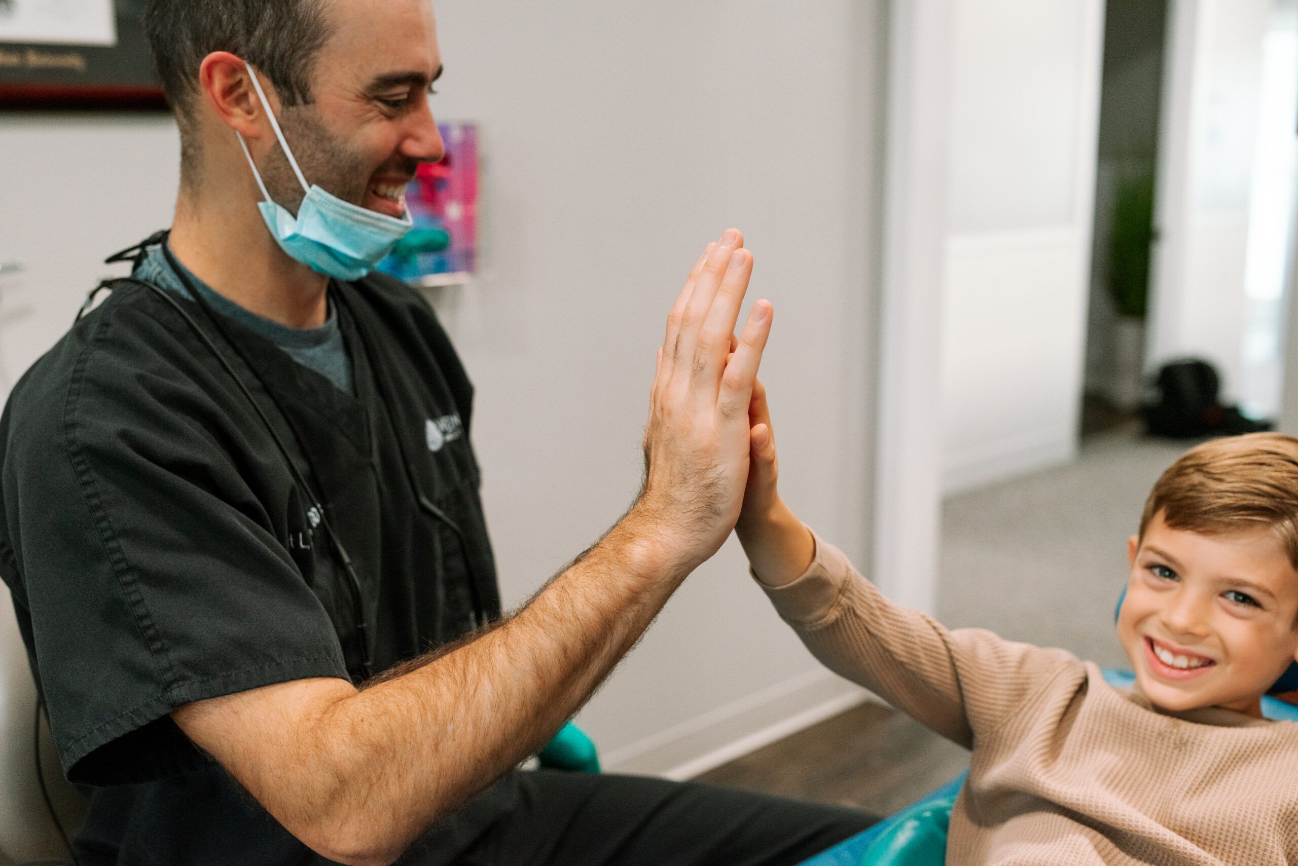 high five dentist and child patient